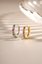 Rainbow-studded 7mm sterling silver and gold huggie earrings by Sami Jewels, showcasing colorful rainbow designs.