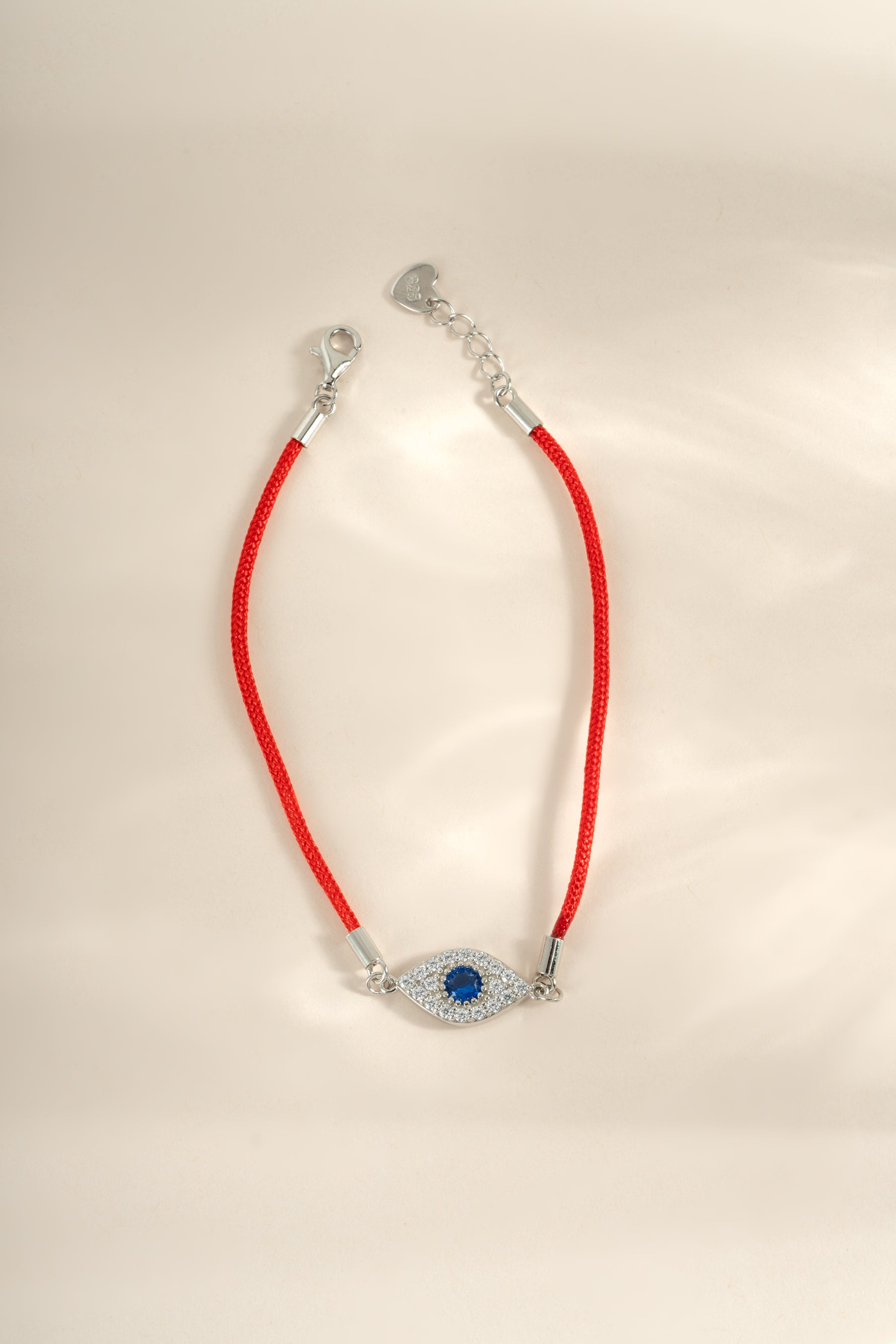 Red string evil eye bracelet by Sami Jewels featuring sterling silver accents, designed to ward off negative energy.