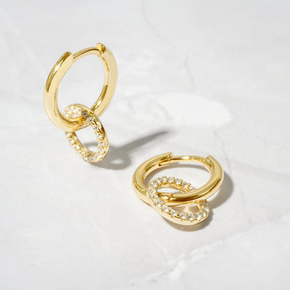 flat lay of Gold Hoop Earrings with removable round pavé charm, designed for a customizable, elegant look.