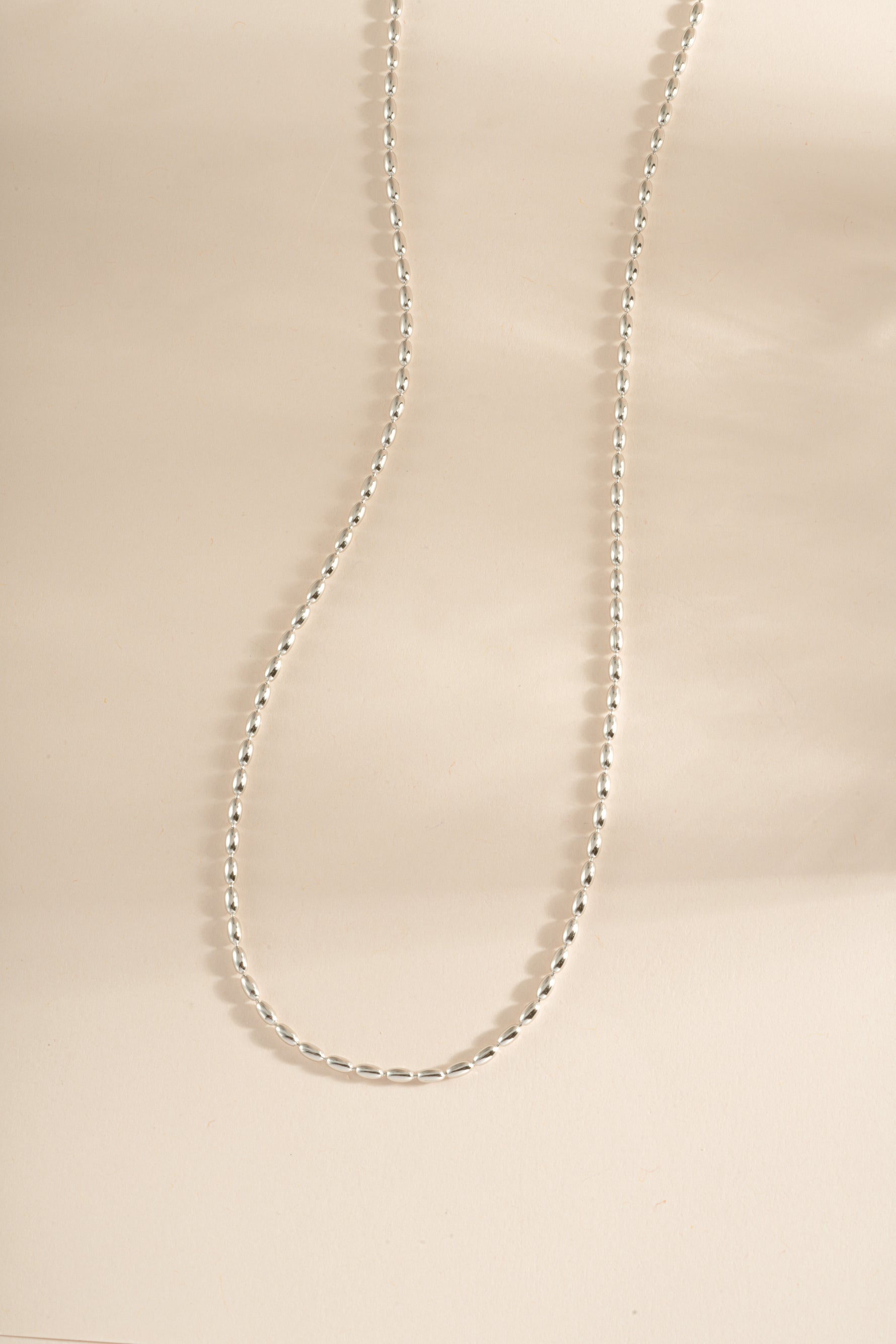Sterling silver Rice Bead Necklace by Sami Jewels featuring small, polished rice-shaped beads on a delicate chain.
