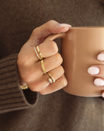 Gold ridged stacking ring from Sami Jewels worn on a model's finger, showcasing its textured design and elegant style.