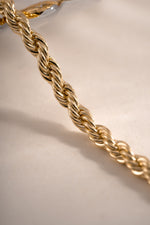 Close-up of a gold rope chain bracelet by Sami Jewels, featuring intricate woven design and polished finish.