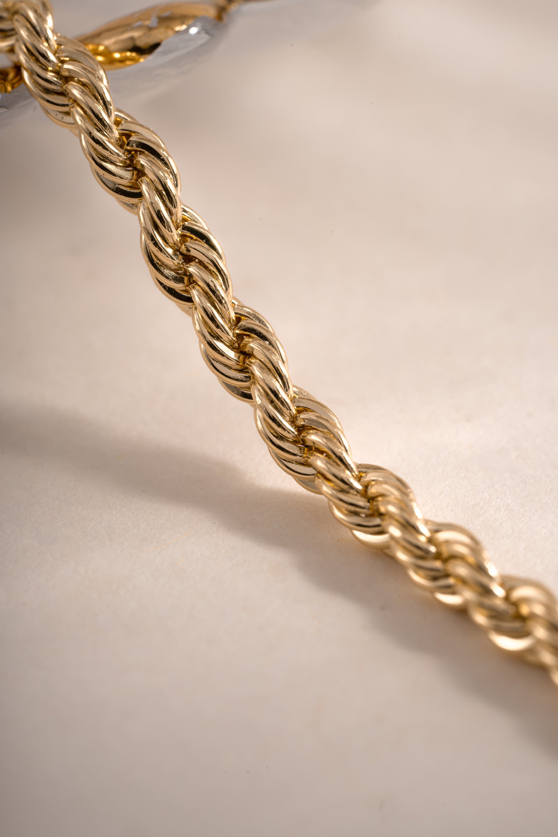 Close-up of a gold rope chain bracelet by Sami Jewels, featuring intricate woven design and polished finish.