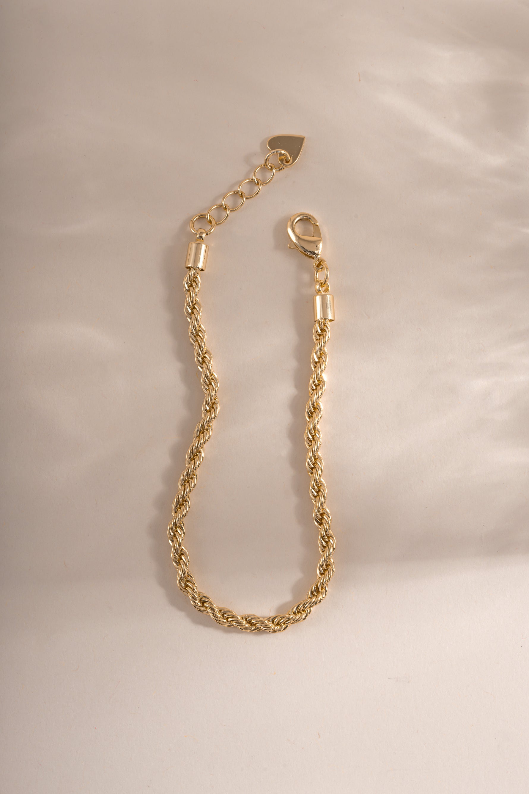 Gold rope chain bracelet by Sami Jewels with lobster clasp closure, featuring a textured braided design.