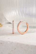rose gold 16mm studded huggie hoop on neutral background