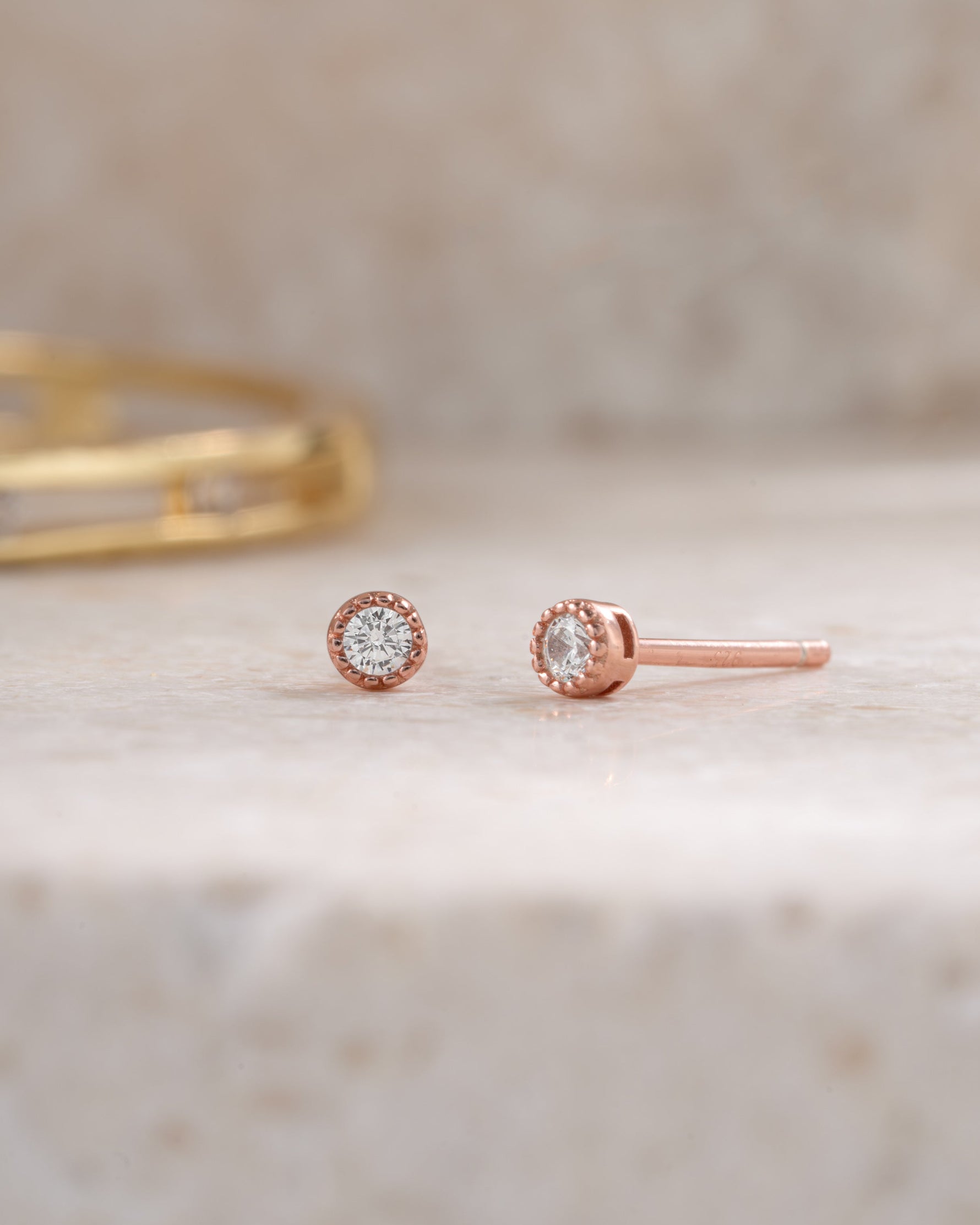 rose gold 2.5mm diamond stud earring neutral background