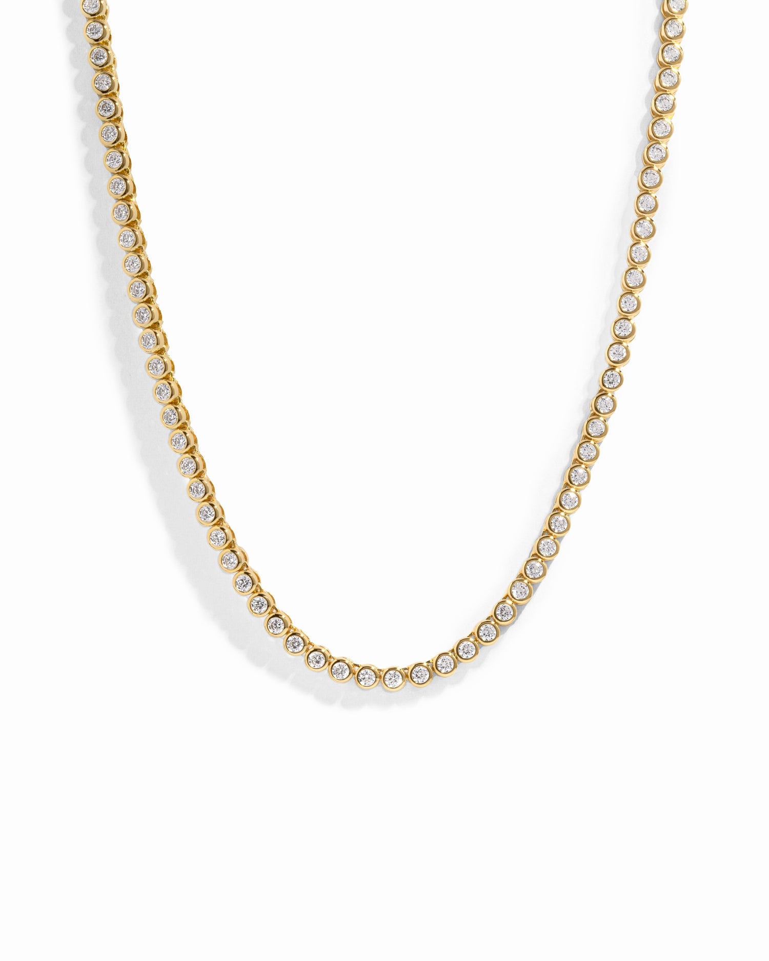 Gold 2.5mm round bezel diamond tennis necklace by Sami Jewels, featuring a sleek design against a white background.