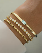 round bezel diamond tennis bracelet stack in gold on a models wrist
