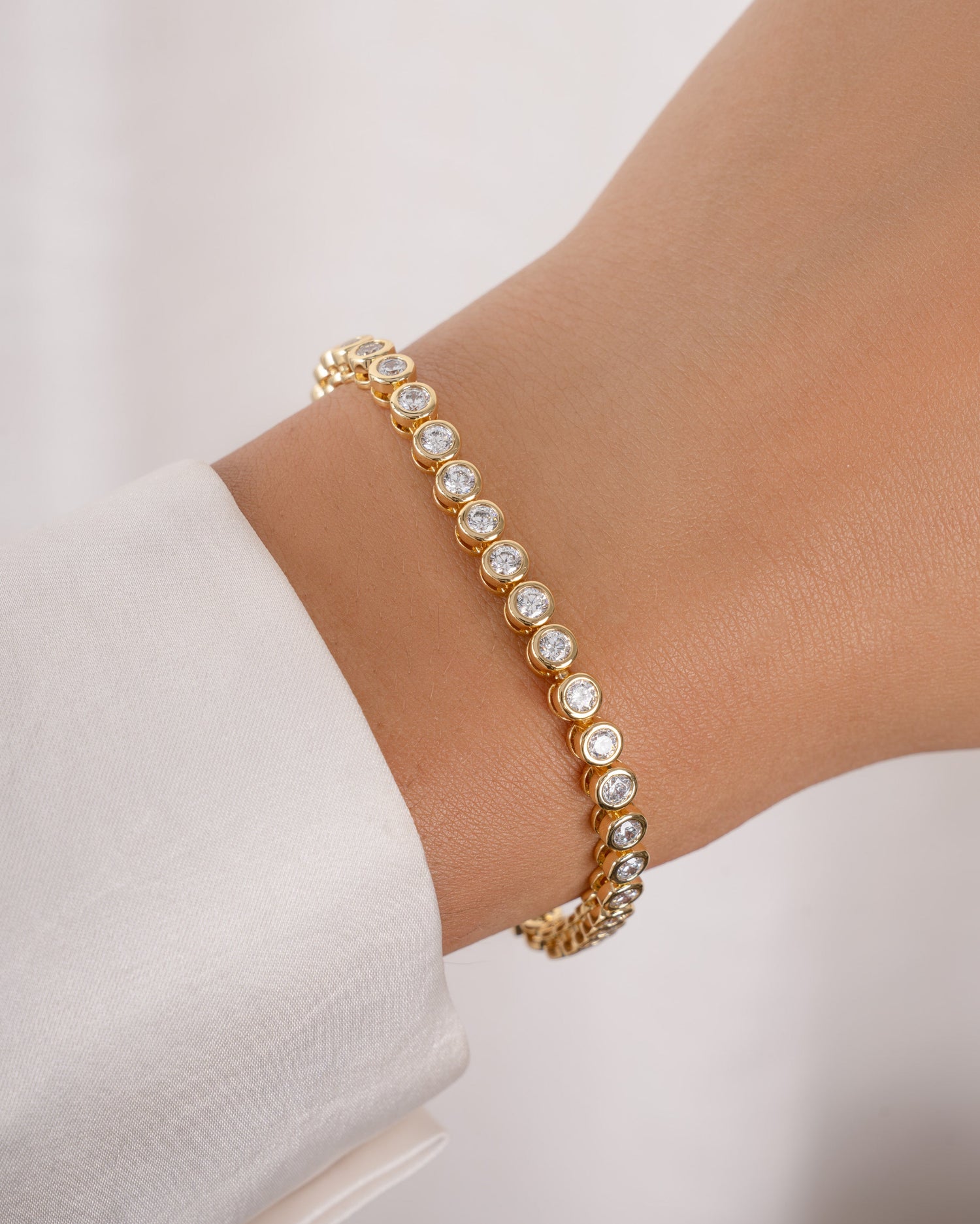 round bezel diamond tennis bracelet, 3mm in gold on a models wrist