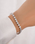 round bezel diamond tennis bracelet in 4mm silver on models wrist