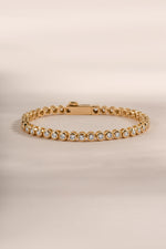 Close-up of Sami Jewels gold round bezel tennis bracelet showcasing polished round bezel settings and fine jewelry craftsmanship.