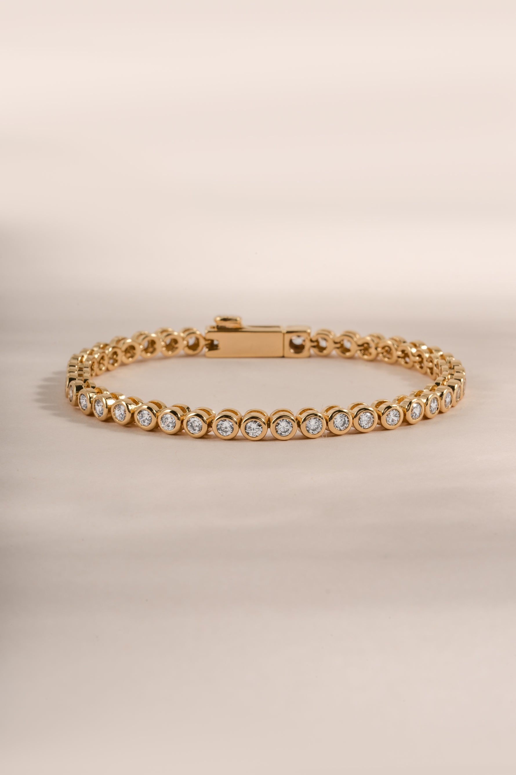Close-up of Sami Jewels gold round bezel tennis bracelet showcasing polished round bezel settings and fine jewelry craftsmanship.