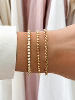 round bezel diamond tennis bracelet gold closeup styled on models wrist