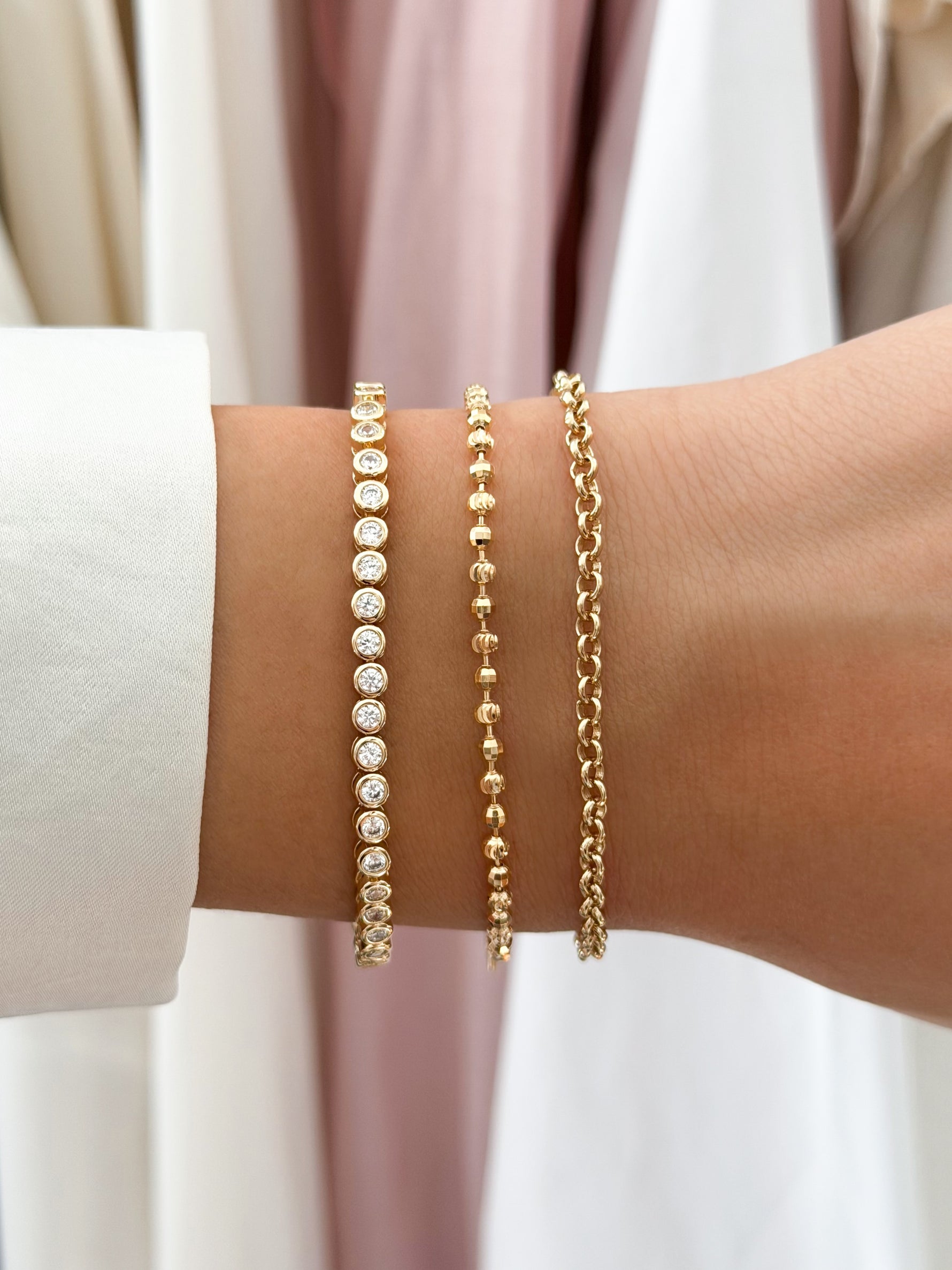 round bezel diamond tennis bracelet gold closeup styled on models wrist