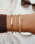 Gold 2.5mm round bezel tennis bracelet by Sami Jewels displayed on a styled model.