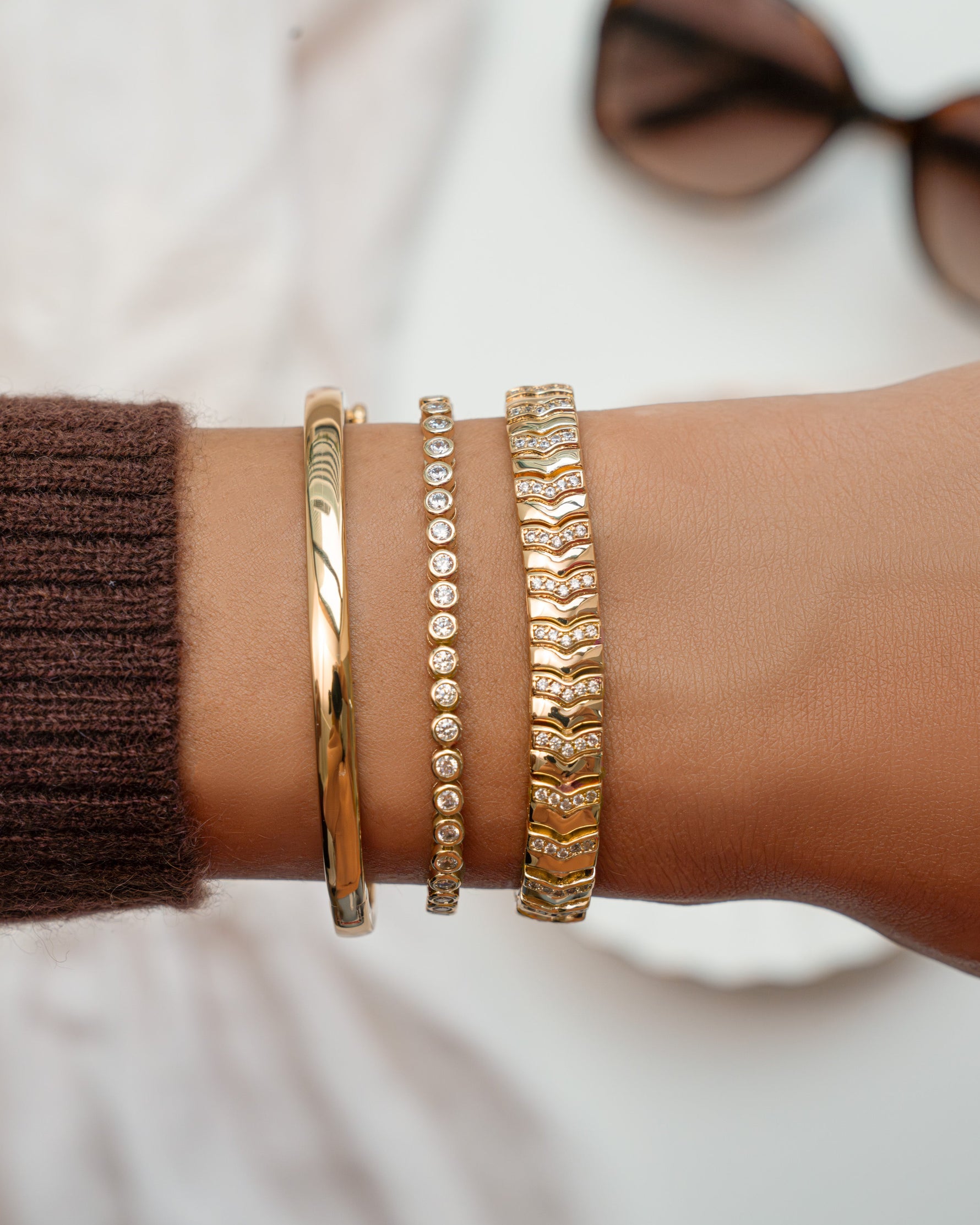 Gold 2.5mm round bezel tennis bracelet by Sami Jewels displayed on a styled model.