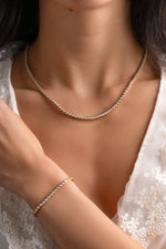 Gold round bezel tennis jewelry bundle from Sami Jewels featuring interconnected chain links and a polished finish.