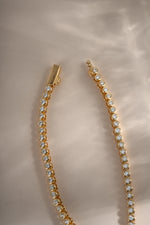 Gold 2.5mm round bezel tennis necklace by Sami Jewels with a box clasp, featuring a sleek and elegant design.