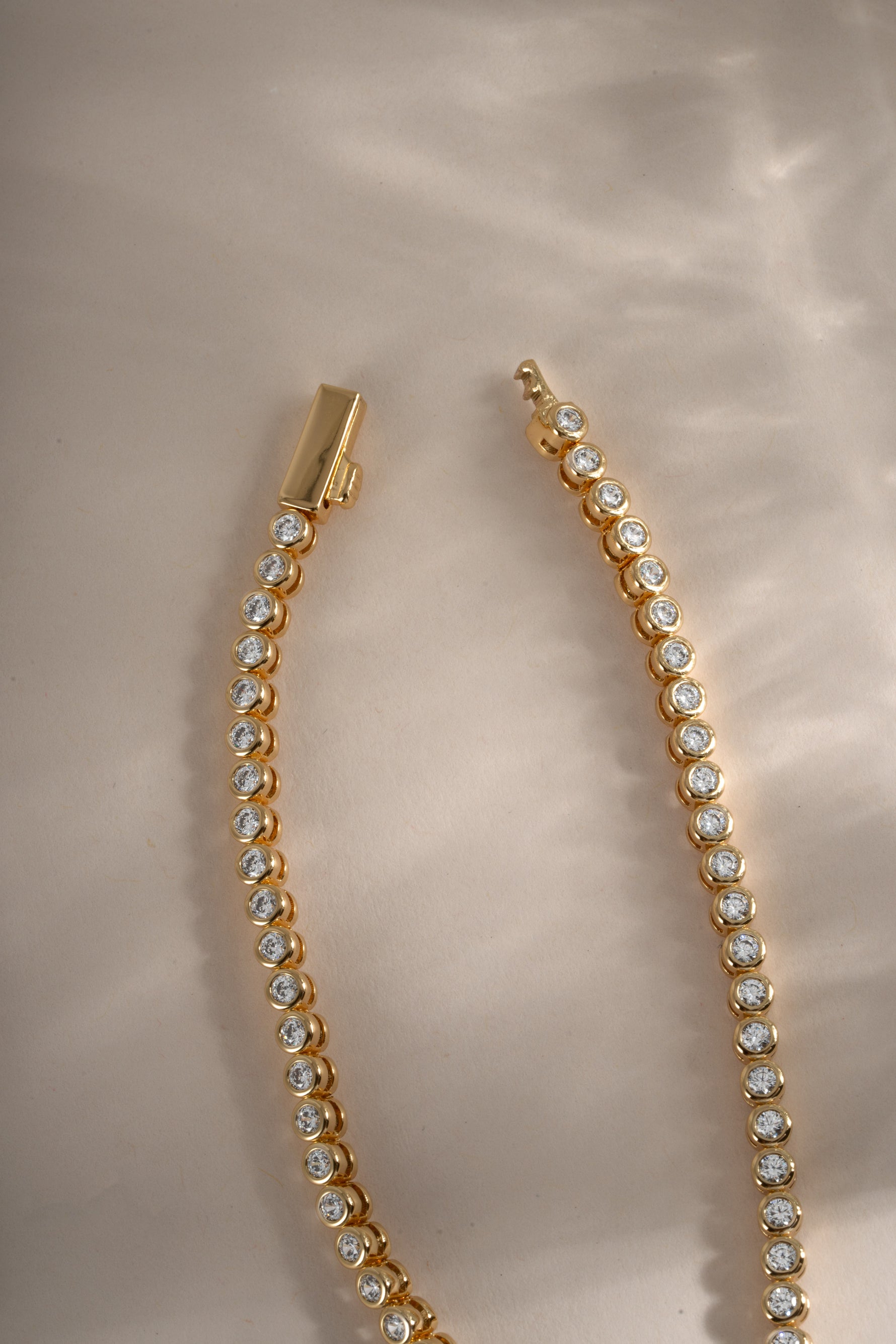 Gold 2.5mm round bezel tennis necklace by Sami Jewels with a box clasp, featuring a sleek and elegant design.