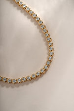 Close-up of a 2.5mm gold round bezel tennis necklace by Sami Jewels, showing the detailed beaded chain and smooth bezel settings.
