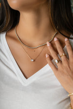 Gold 2.5mm round bezel tennis necklace by Sami Jewels worn on a model, showcasing elegant jewelry design and fine craftsmanship.