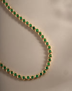 Detail of bezel-set round green stones on emerald tennis necklace, view 4