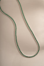 Detail of bezel-set round green stones on emerald tennis necklace, view 5