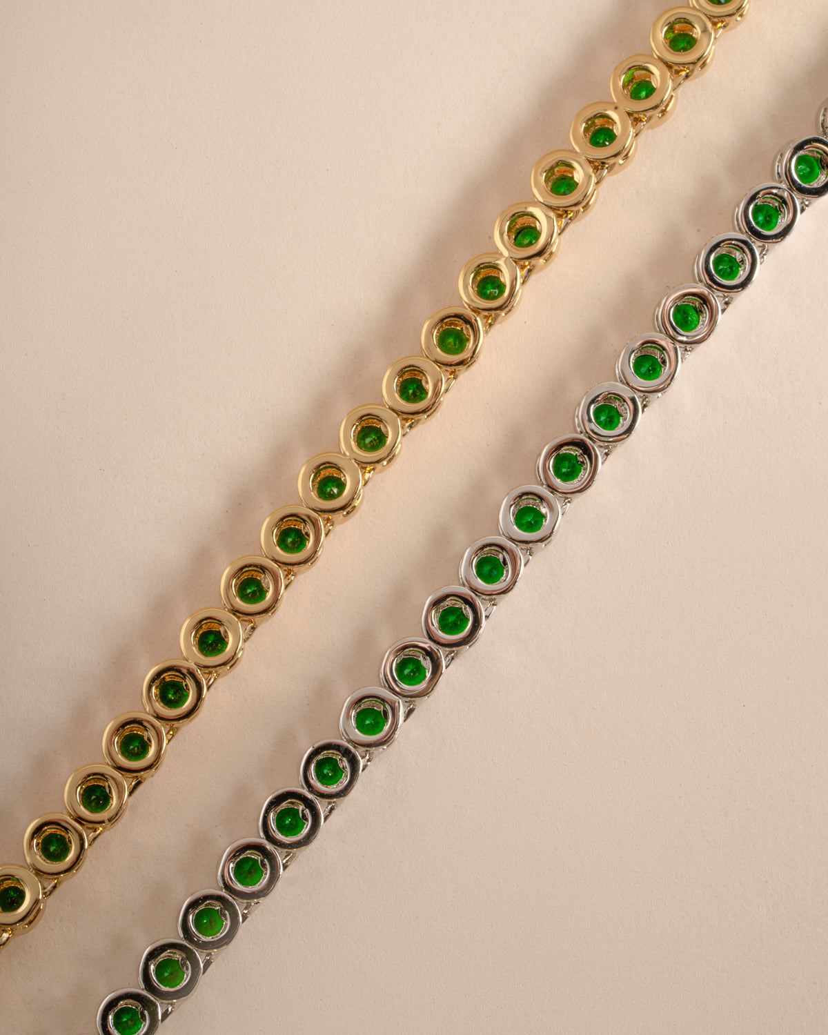 Detail of bezel-set round green stones on emerald tennis necklace, view 6