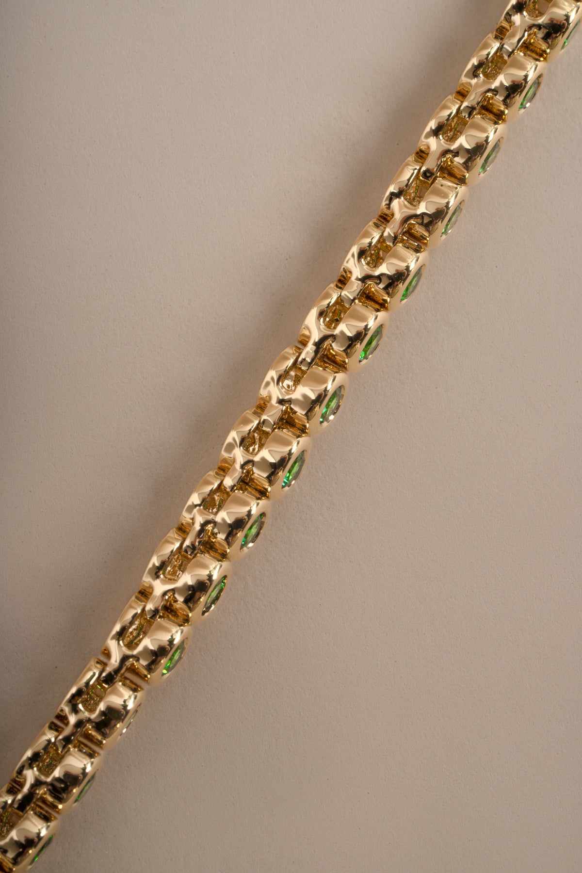 Detail of bezel-set round green stones on emerald tennis necklace, view 7