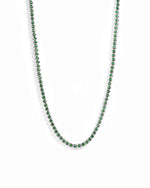 Rhodium plated silver round emerald tennis necklace on white background