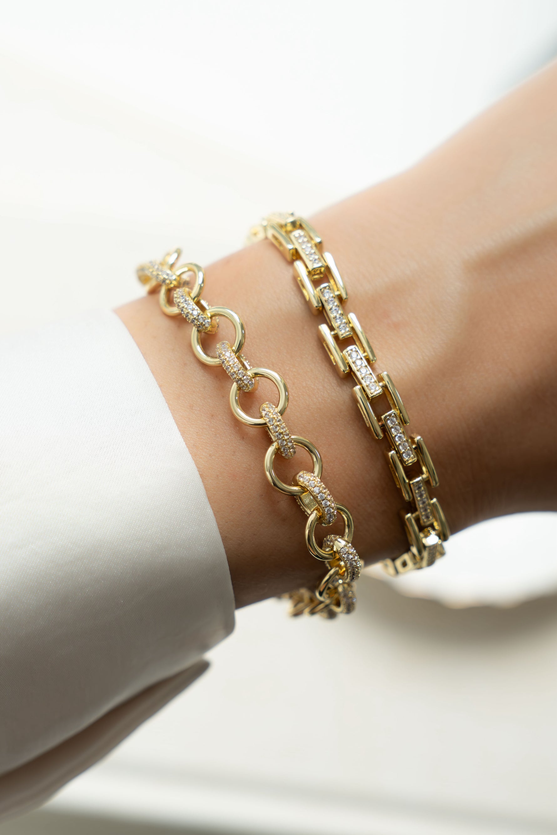 Gold Sami Jewels round pave link bracelet stacked on a model's wrist, showcasing elegant jewelry design.