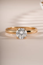 Close-up of Sami Jewels gold round solitaire ring showcasing a single sparkling gemstone on a smooth band.