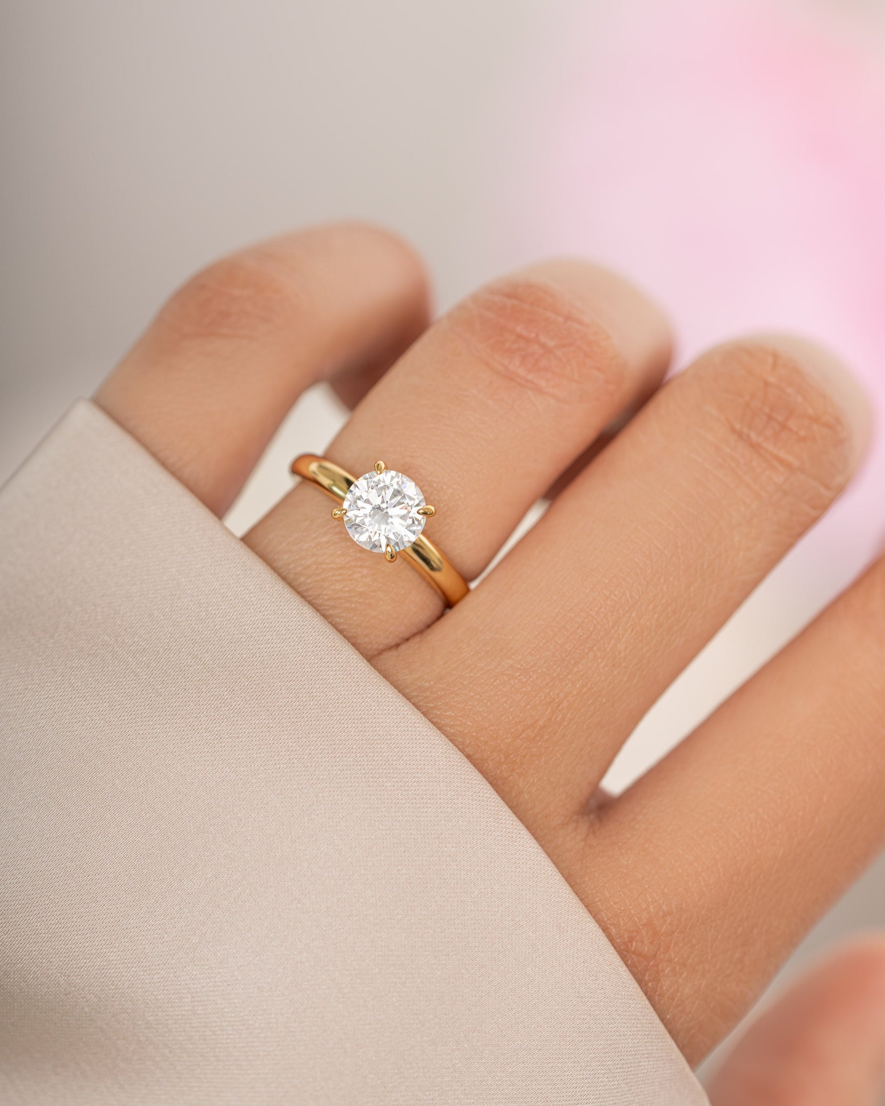 Gold round solitaire ring by Sami Jewels featuring a single sparkling gemstone on a sleek band.