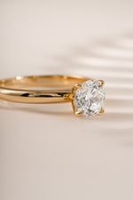 Gold round solitaire ring by Sami Jewels featuring a central stone and sleek band design.