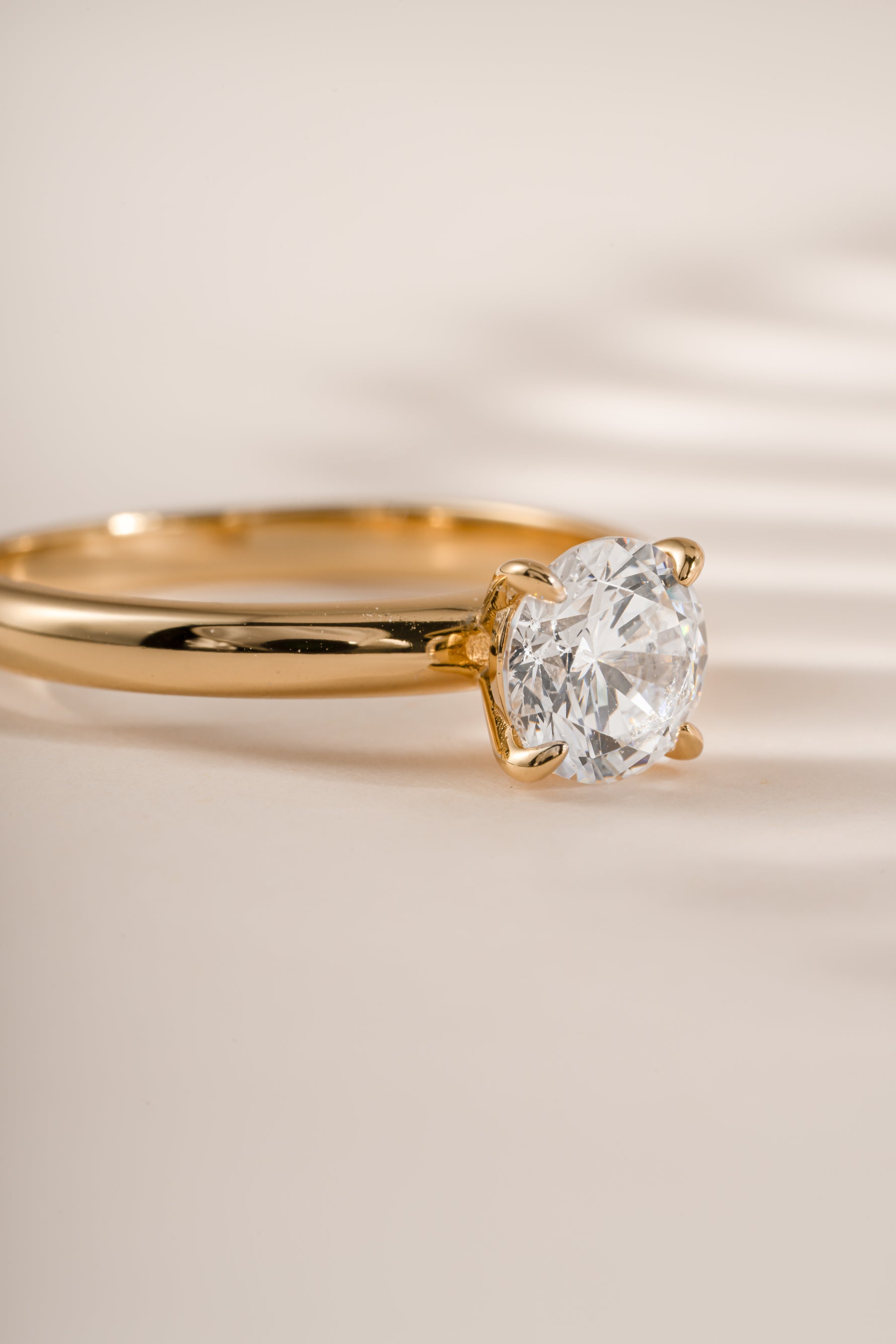 Gold round solitaire ring by Sami Jewels featuring a central stone and sleek band design.