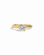 Gold round solitaire ring by Sami Jewels featuring a single sparkling gemstone on a white background.