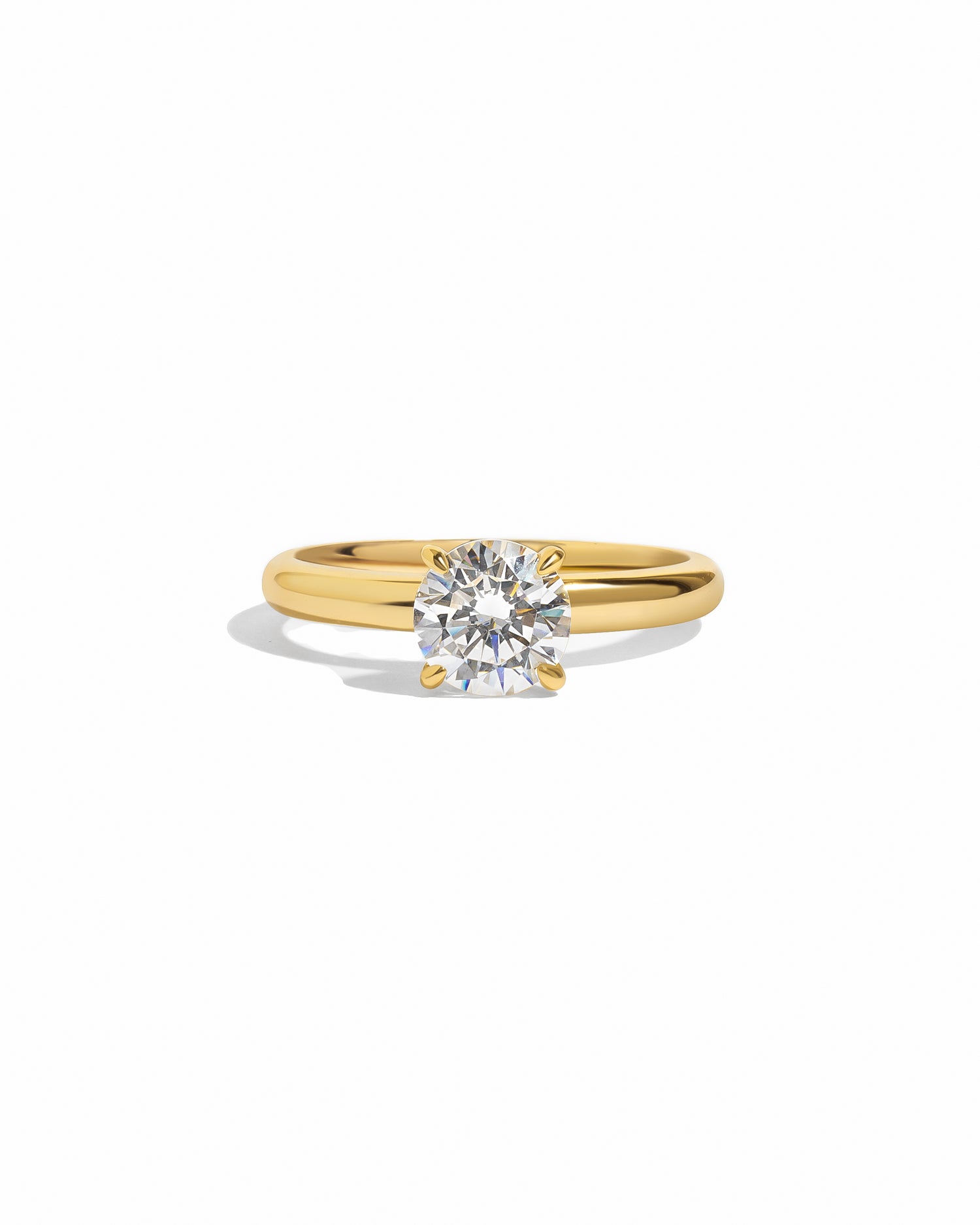 Gold round solitaire ring by Sami Jewels featuring a single sparkling gemstone on a white background.