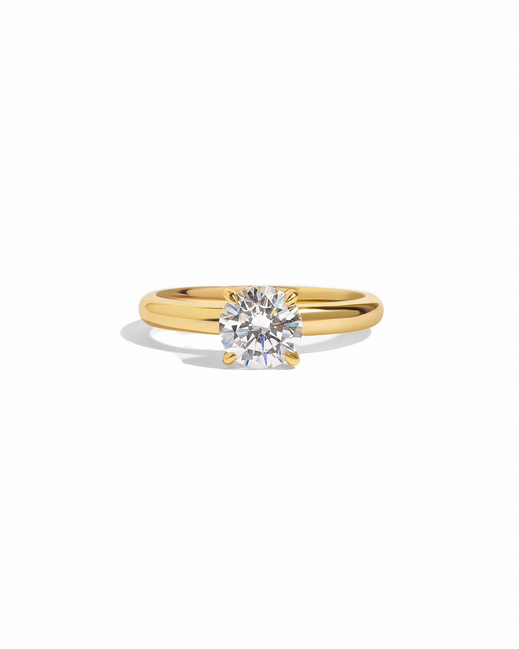 Gold round solitaire ring by Sami Jewels featuring a single sparkling gemstone on a white background.