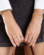 Gold round solitaire ring from Sami Jewels, showcasing a sleek, elegant design on a model's finger.