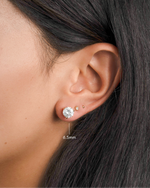 round solitaire stud earrings in gold, 6.5mm on models ear