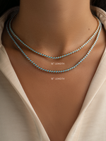 Stacked round turquoise tennis necklaces by Sami Jewels featuring gold chain links and vibrant turquoise stones.