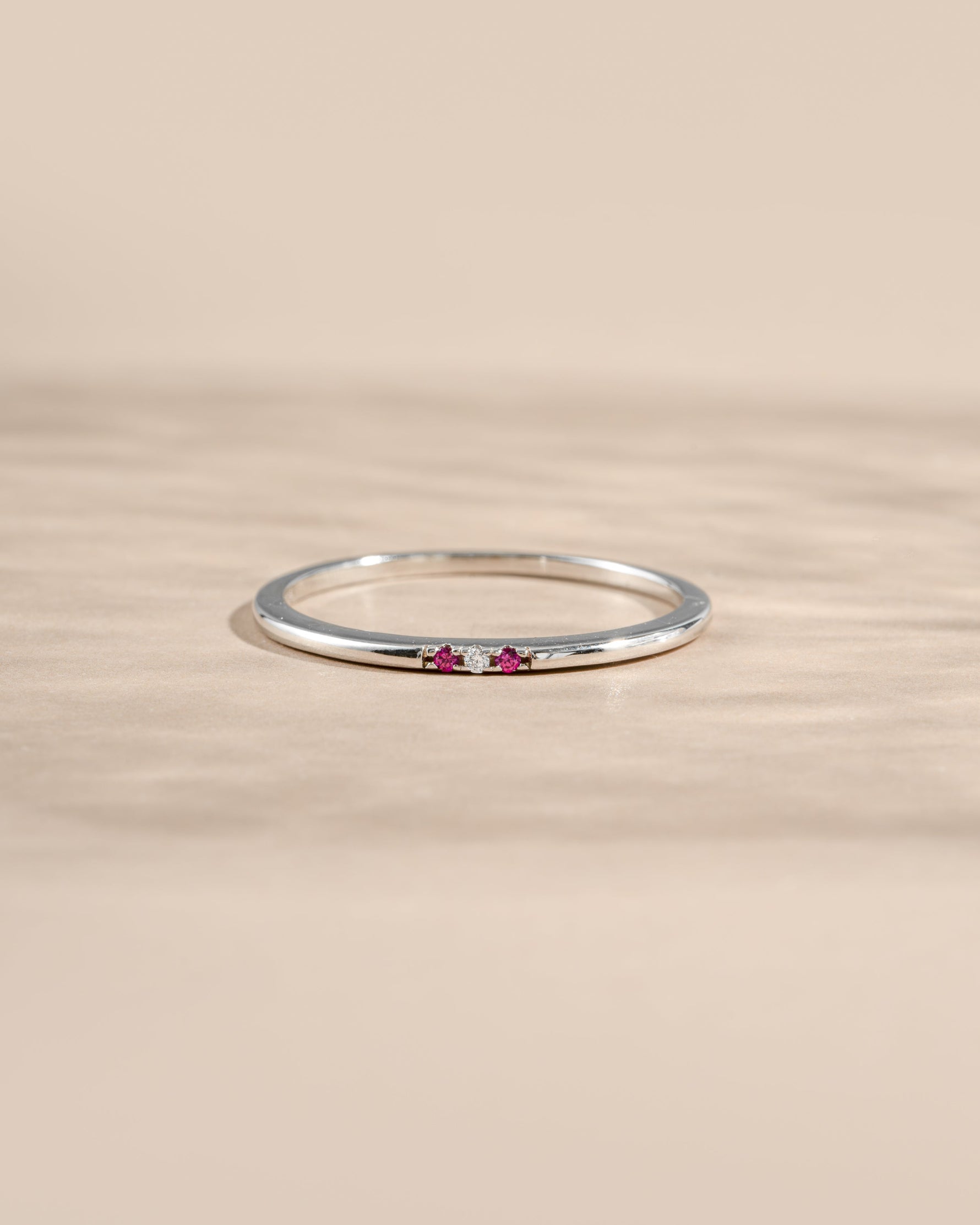 ruby 3 stone stacking ring in sterling silver on a neutral background