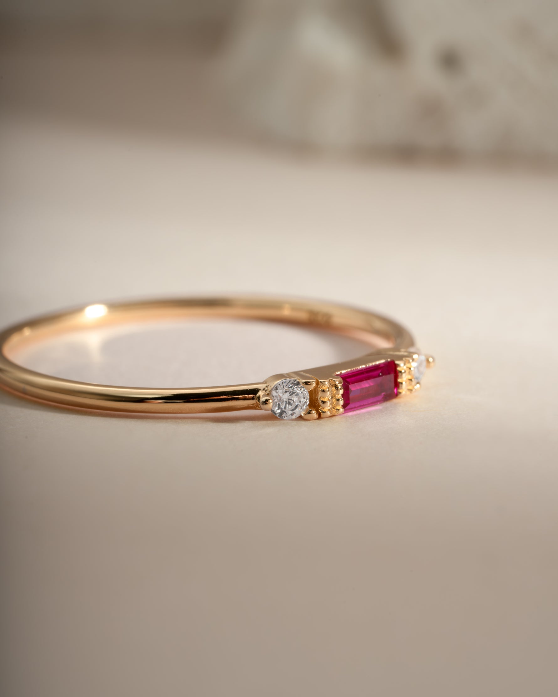 Close-up of Sami Jewels Ruby Baguette Ring featuring a gold band and a vibrant ruby baguette gemstone.
