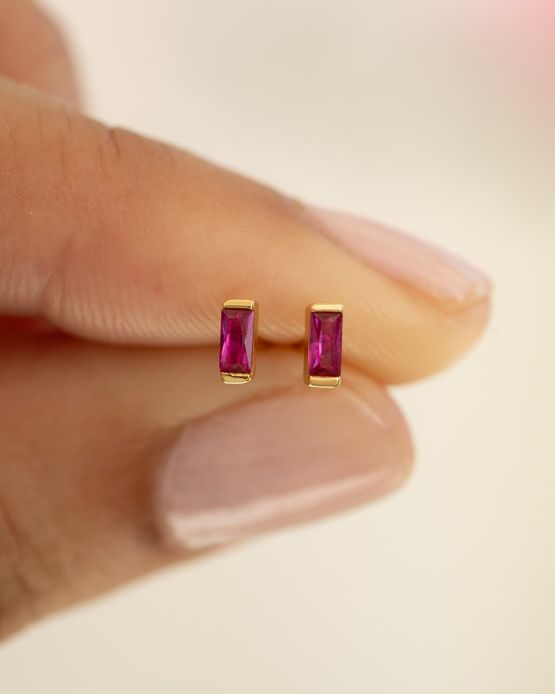 Close-up of gold Ruby Baguette Stud Earrings by Sami Jewels showcasing sparkling baguette-cut rubies and sleek earring design