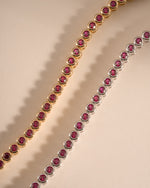 Sami Jewels Ruby Bezel Tennis Bracelet in gold and silver finishes, featuring a row of sparkling rubies in a sleek, elegant design.