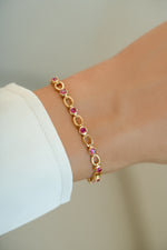 Gold Ruby Lilly Tennis Bracelet on wrist model by Sami Jewels featuring sparkling ruby stones and elegant design.