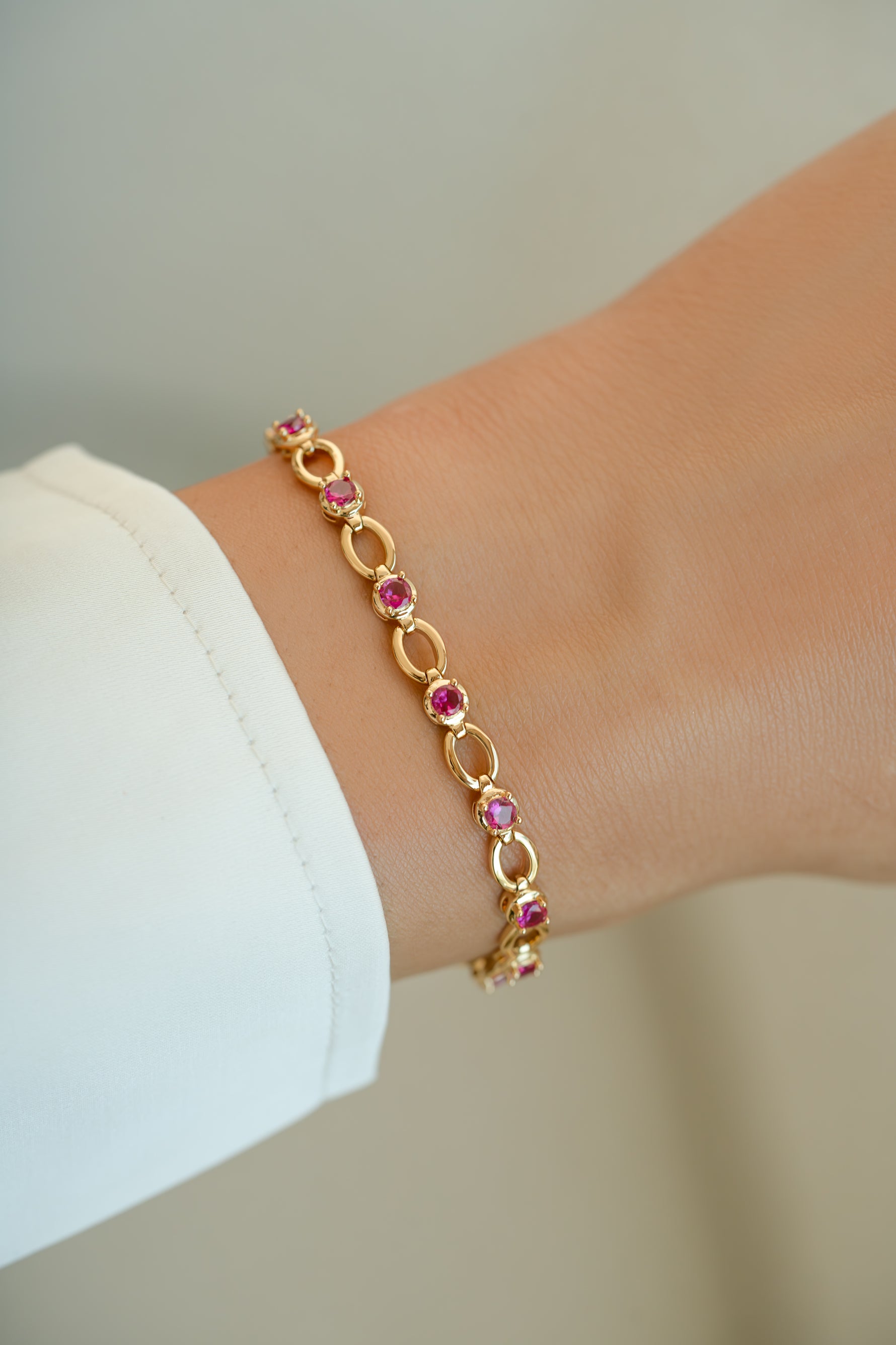 Gold Ruby Lilly Tennis Bracelet on wrist model by Sami Jewels featuring sparkling ruby stones and elegant design.