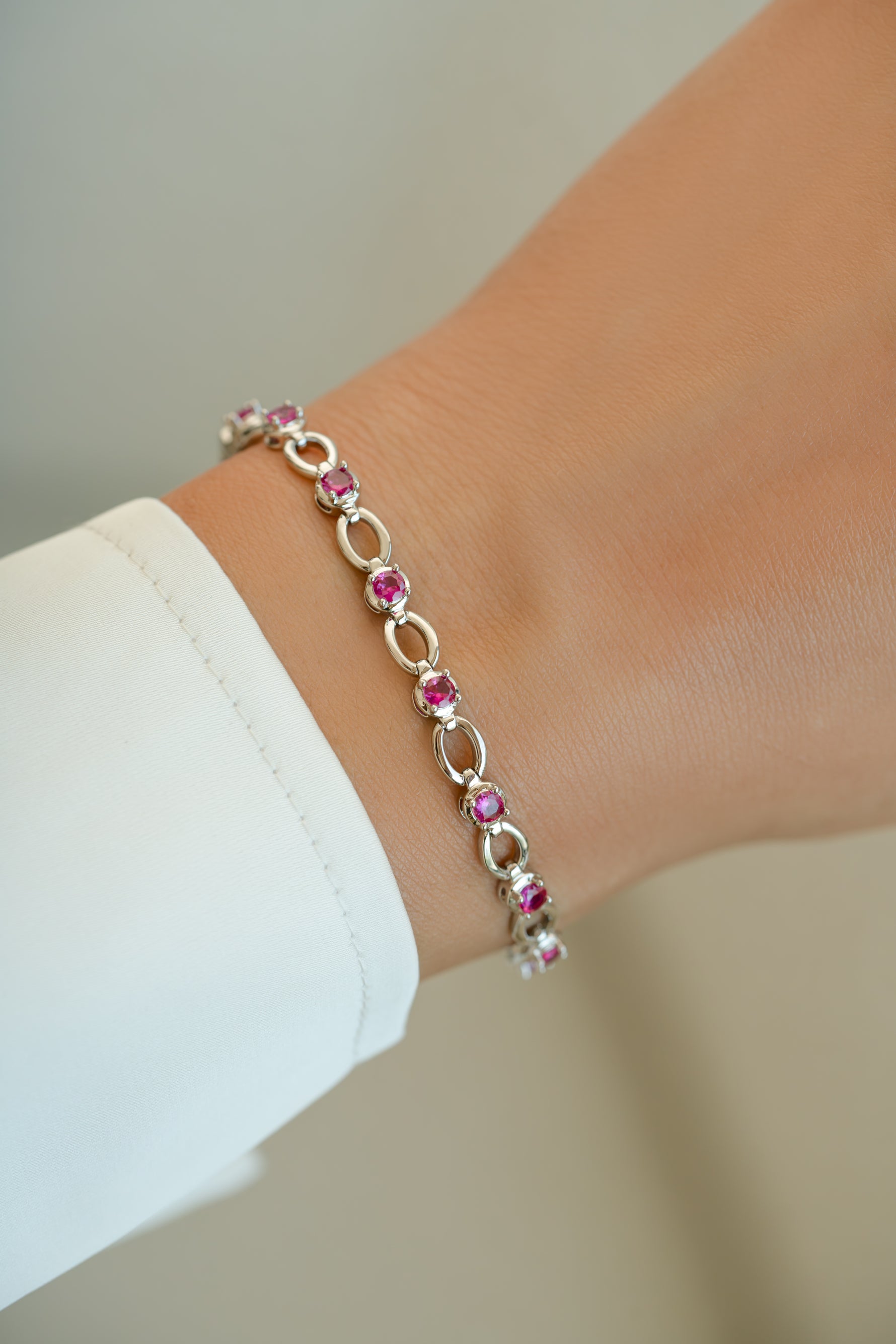 Ruby Lilly Tennis Bracelet by Sami Jewels featuring vibrant rubies on a sleek silver bracelet worn on a wrist.