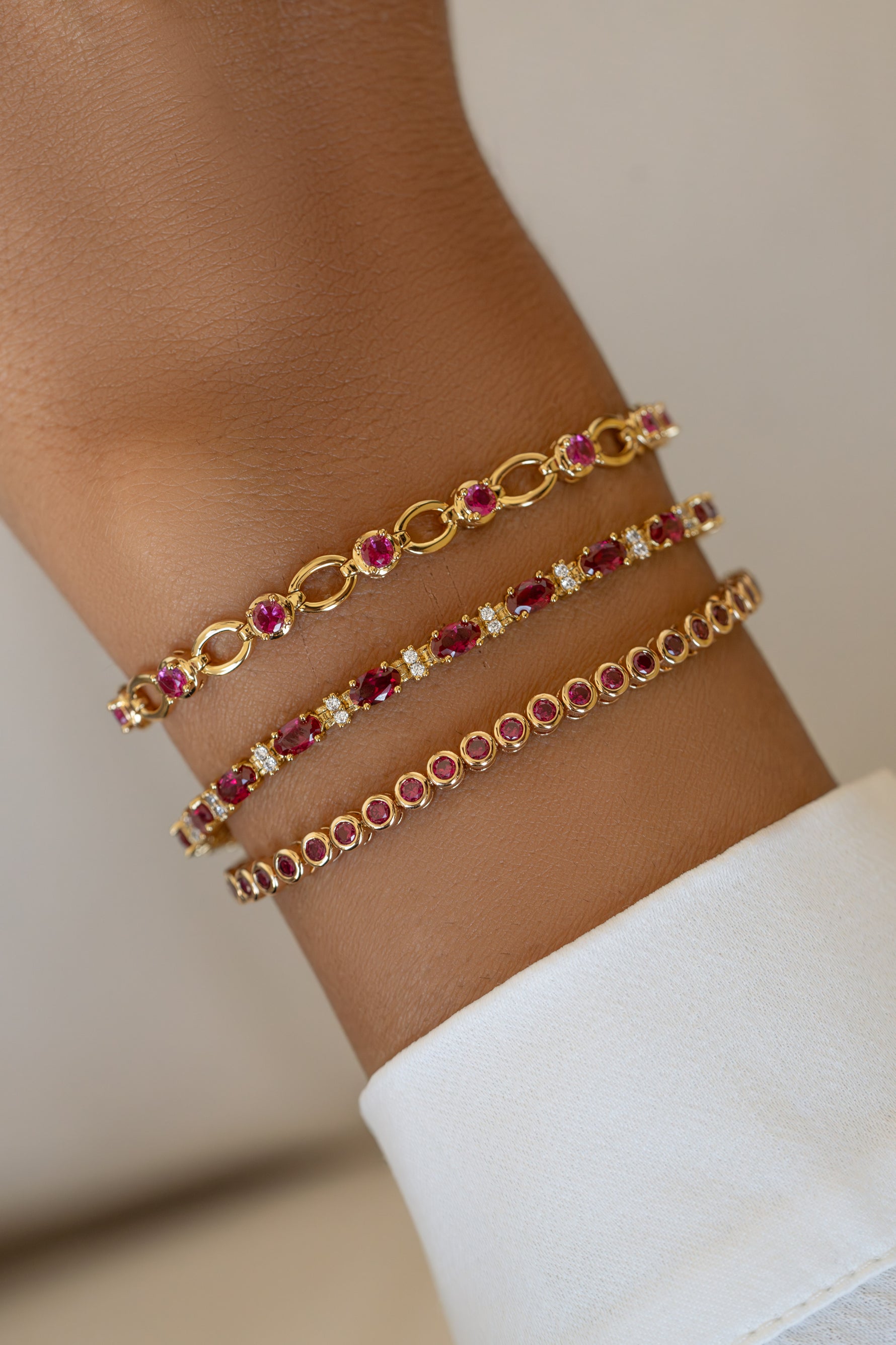 Sami Jewels Ruby Lilly Tennis Bracelet featuring red rubies and diamond accents on a gold bracelet worn on a model