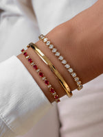 Sami Jewels Ruby Tennis Bracelet featuring a stack of gold-styled diamond and ruby tennis bracelets worn on a model's wrist